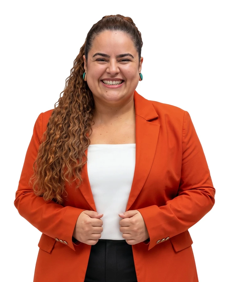 Myle Pontes, fundadora e CEO da Beorange, sorrindo, de blazer laranja sobre blusa branca, com as mãos na lapela